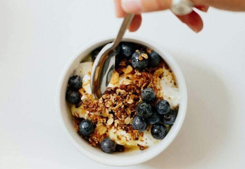 Joghurt mit Beeren, Granola und Nüssen als gesunder Snack für zwischendurch