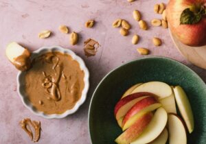 Apfelscheiben mit Mandelmus und Zimt als gesunder Snack